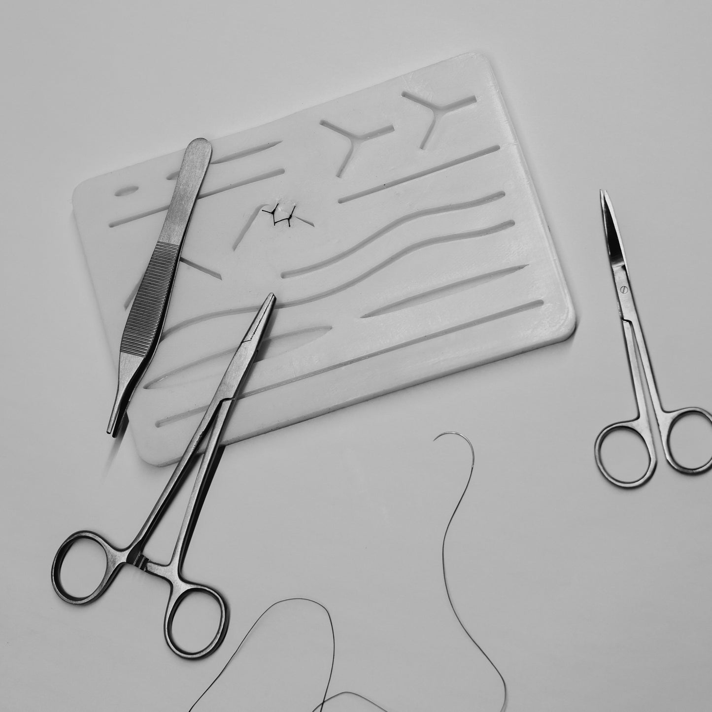 Set of scissors and a cutting mat with patterns on a light gray background